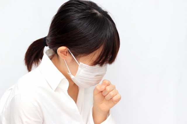 咳をしているマスクをした女性